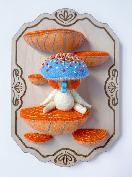 Hannakin - 'Sitting on the Shelf' - wool felt, cotton, glass beads, magnet and mixed media on birch plywood plaque