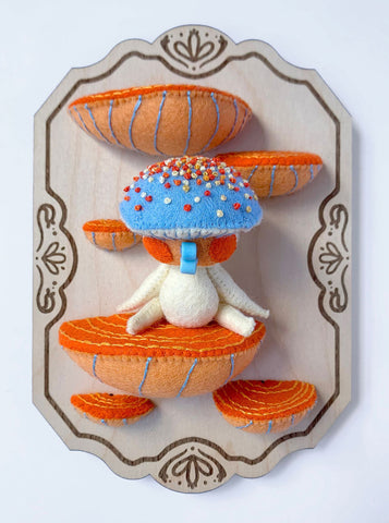 Hannakin - 'Sitting on the Shelf' - wool felt, cotton, glass beads, magnet and mixed media on birch plywood plaque